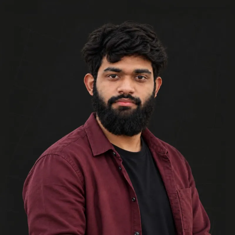 Portrait of Shahriar Ahmed Shovon, in a maroon shirt against a dark background.